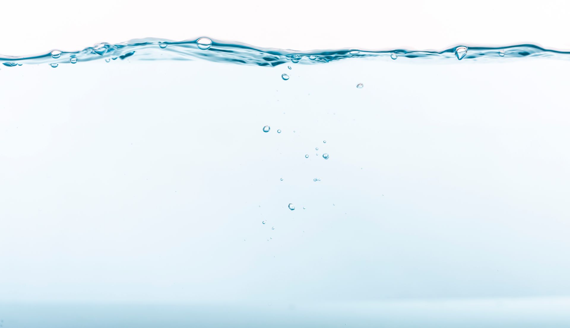 A stream of clear water against a light blue background. The water is partially frozen, showing some texture.