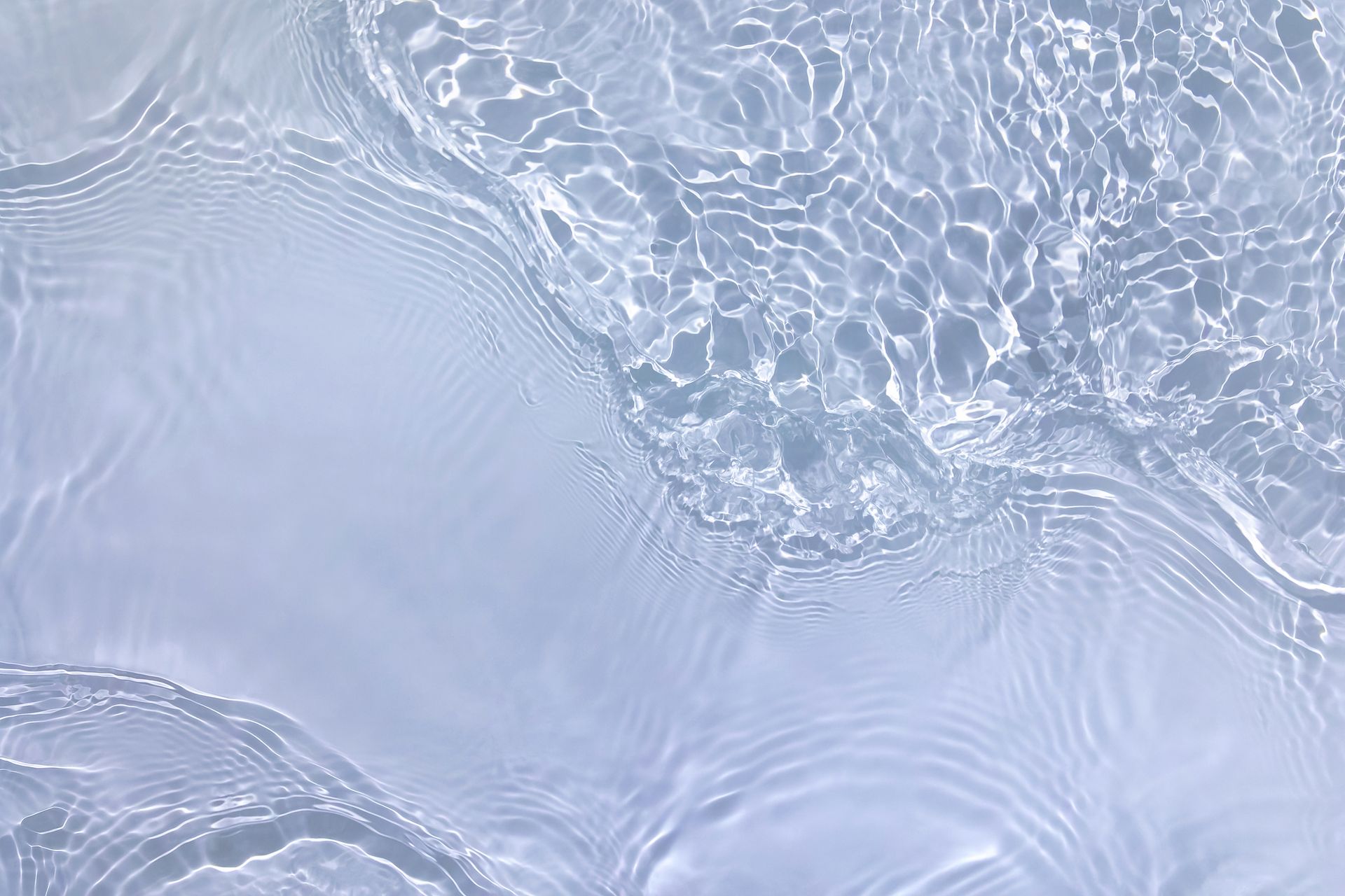 Clear water surface with rippling reflections, shades of blue and white.