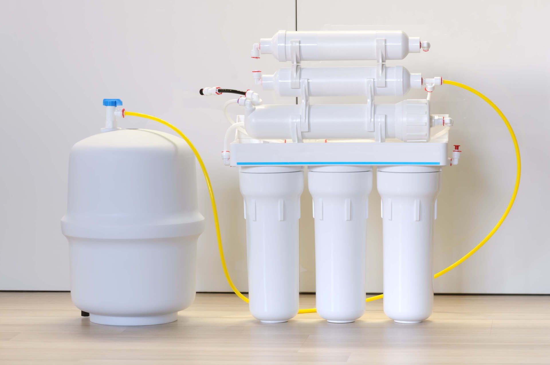White reverse osmosis water filter system with a storage tank, set against a plain white background. White reverse osmosis water filter system with a storage tank, set against a plain white background.