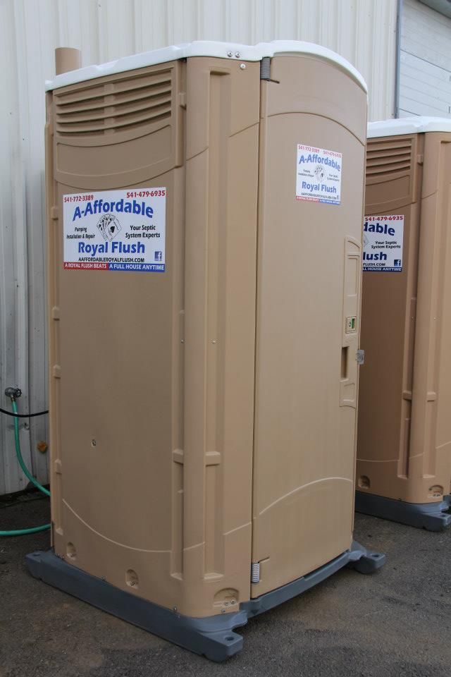 Tan portable toilet with business logo, next to another one.