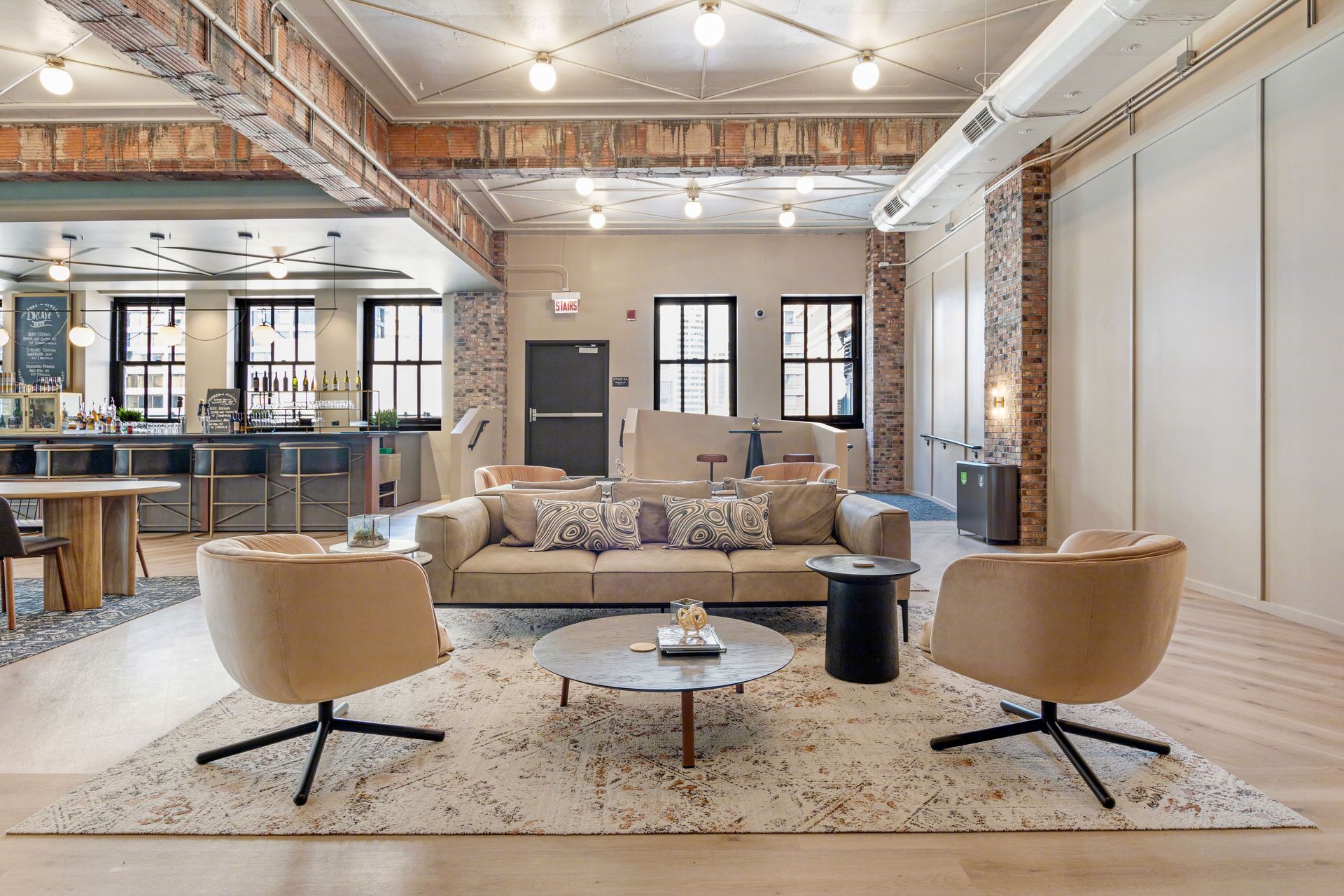 A living room with a couch , chairs , a table and a rug.