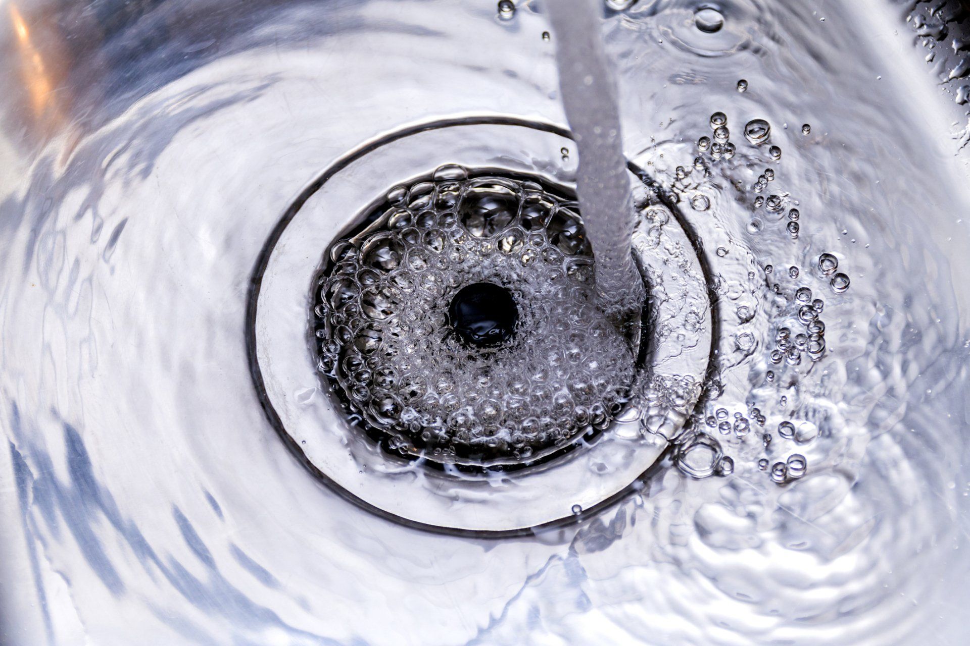 silver sink with water going down drain