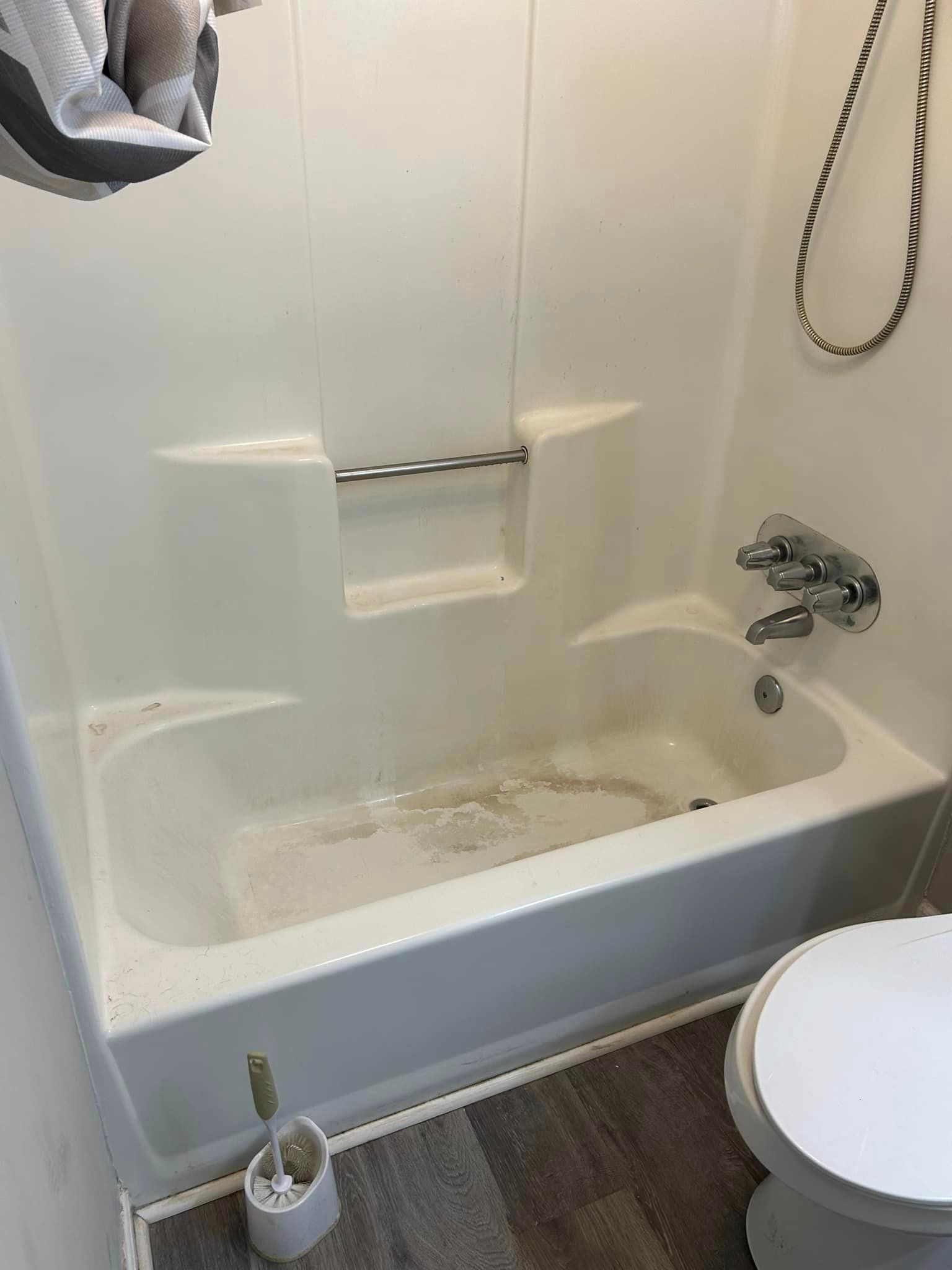 A bathroom with a bathtub , toilet and shower.