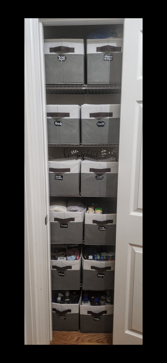 A closet filled with gray storage bins, neatly organized on shelves. White doors frame the storage space.