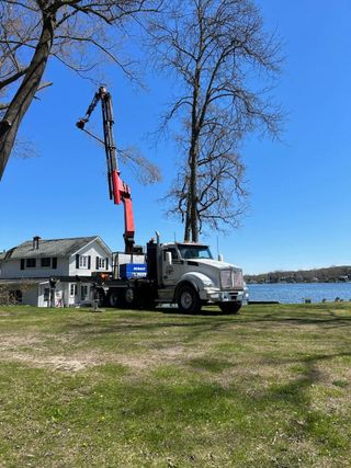 A truck with a crane attached to it is parked in front of a house.