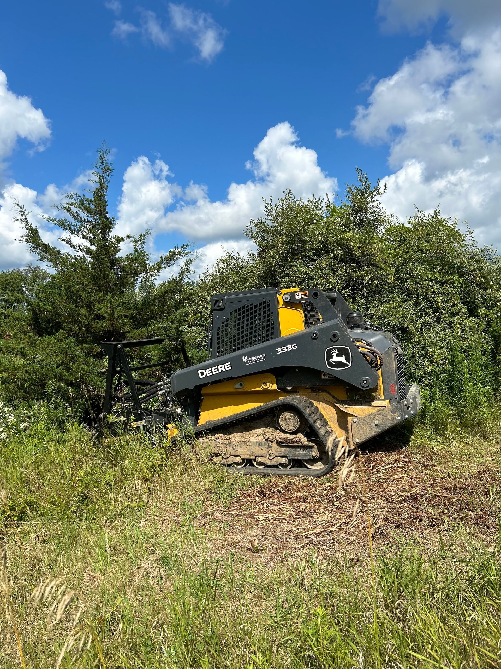 A bulldozer is sitting in the middle of a grassy field.