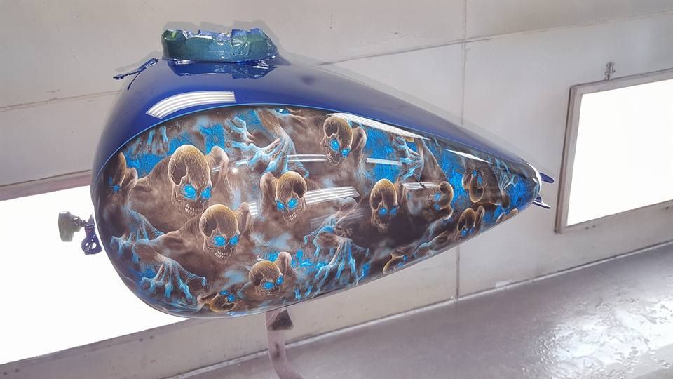 A blue motorcycle tank with a picture of rams on it
