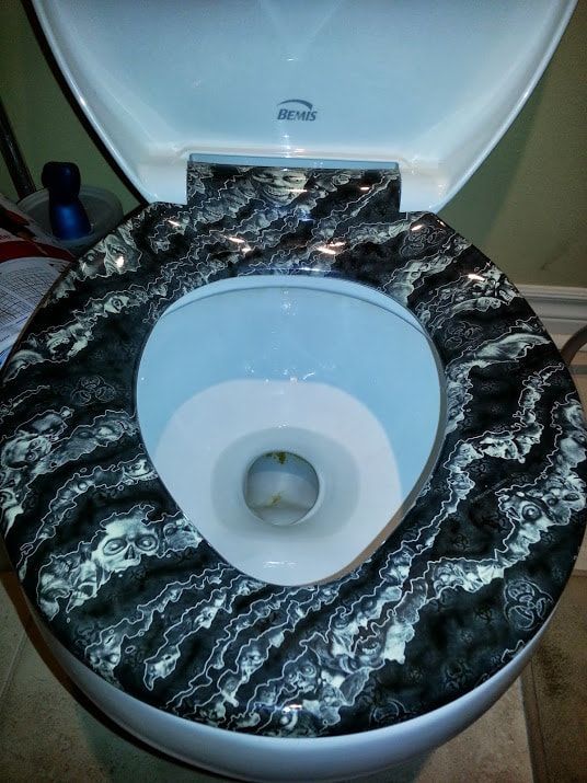 A toilet with a black and white marble seat
