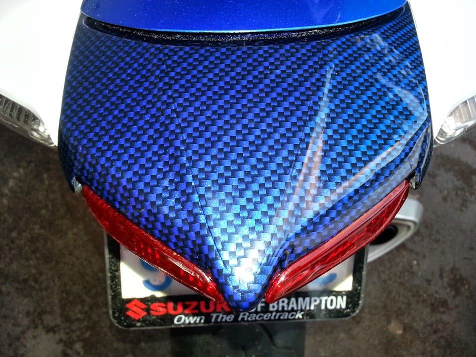 A blue suzuki motorcycle with a license plate that says brampton