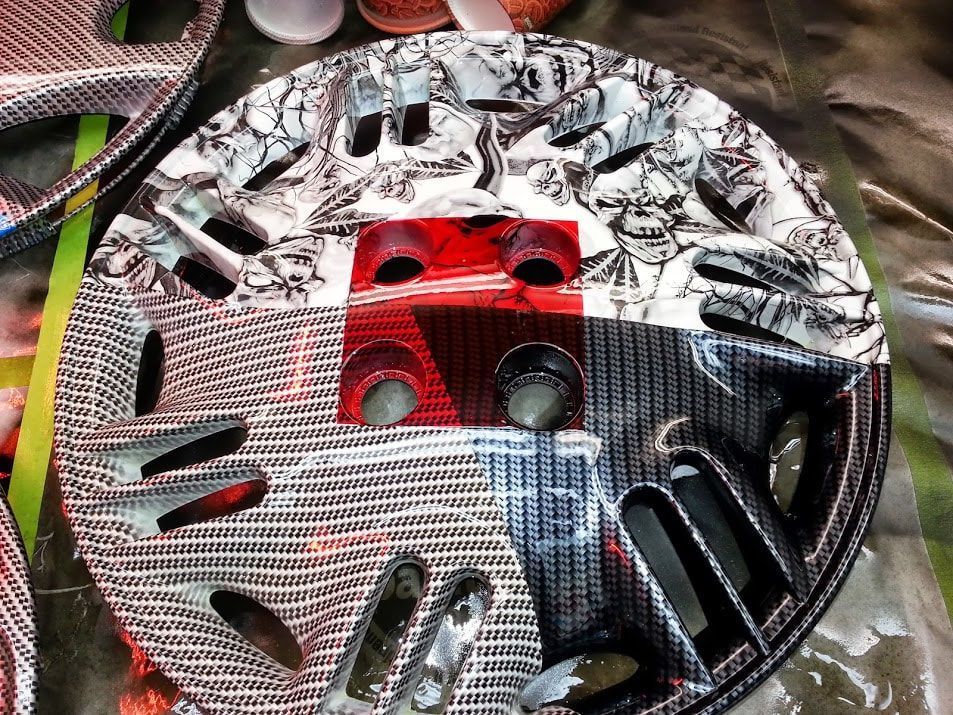 A close up of a wheel cover with a skull design on it.