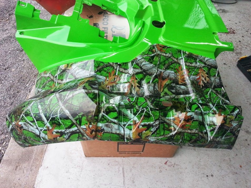 A green camo item is sitting on top of a cardboard box