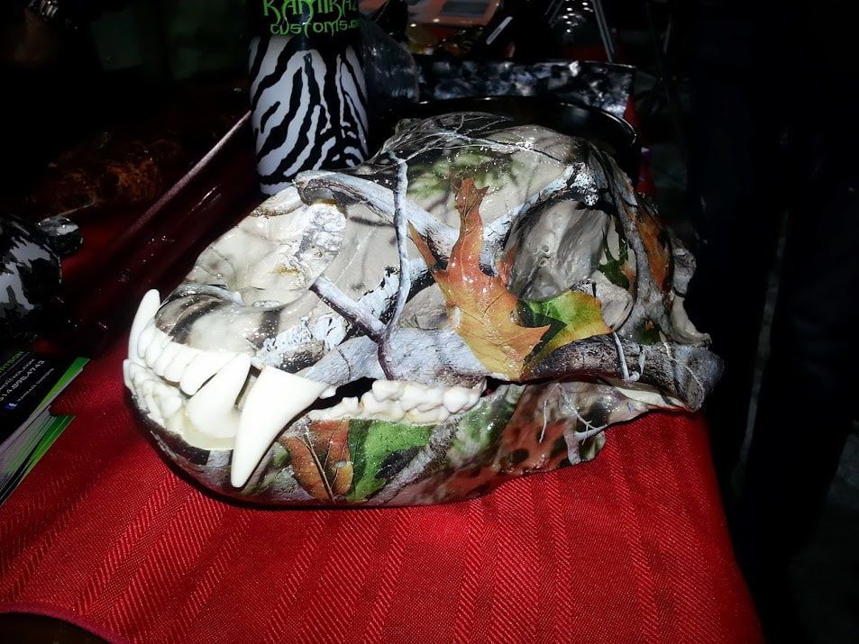 A camouflaged skull is sitting on a red table.