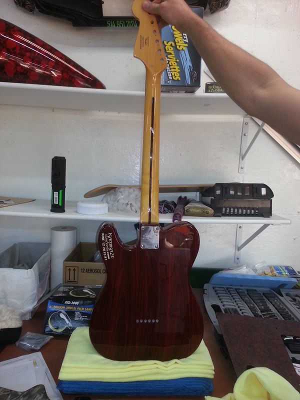 A person is holding a guitar in front of a shelf that says ' jackson ' on it