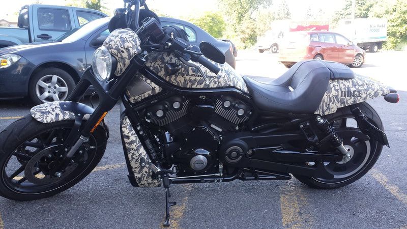 A motorcycle is parked in a parking lot next to a car.