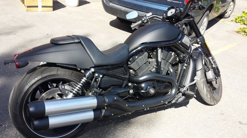 A black harley davidson motorcycle is parked in a parking lot