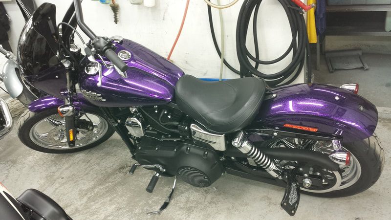 A purple harley davidson motorcycle is parked in a garage