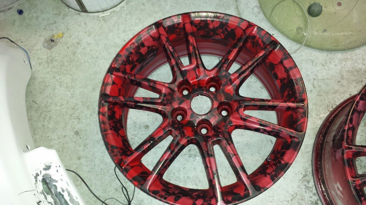 A red wheel is sitting on a white surface