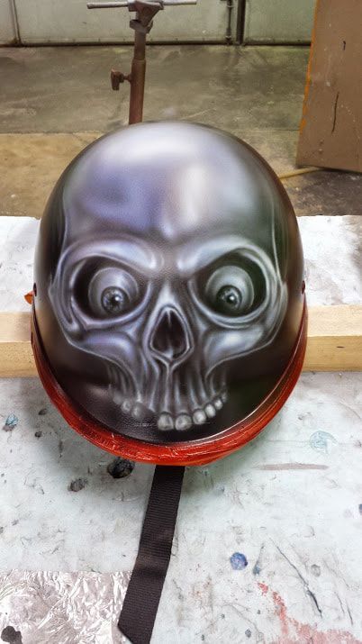 A helmet with a skull painted on it is sitting on a table.