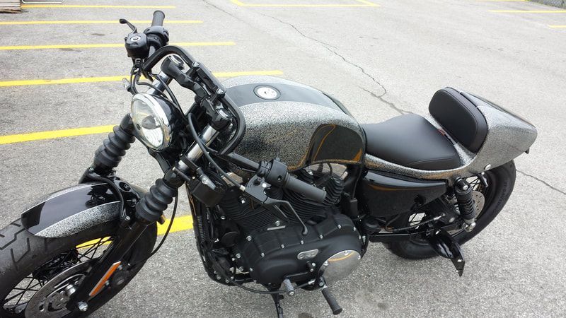 A black motorcycle is parked in a parking lot