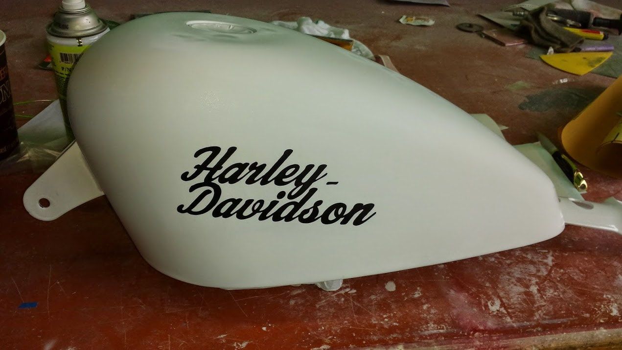 A white harley davidson tank is sitting on a table