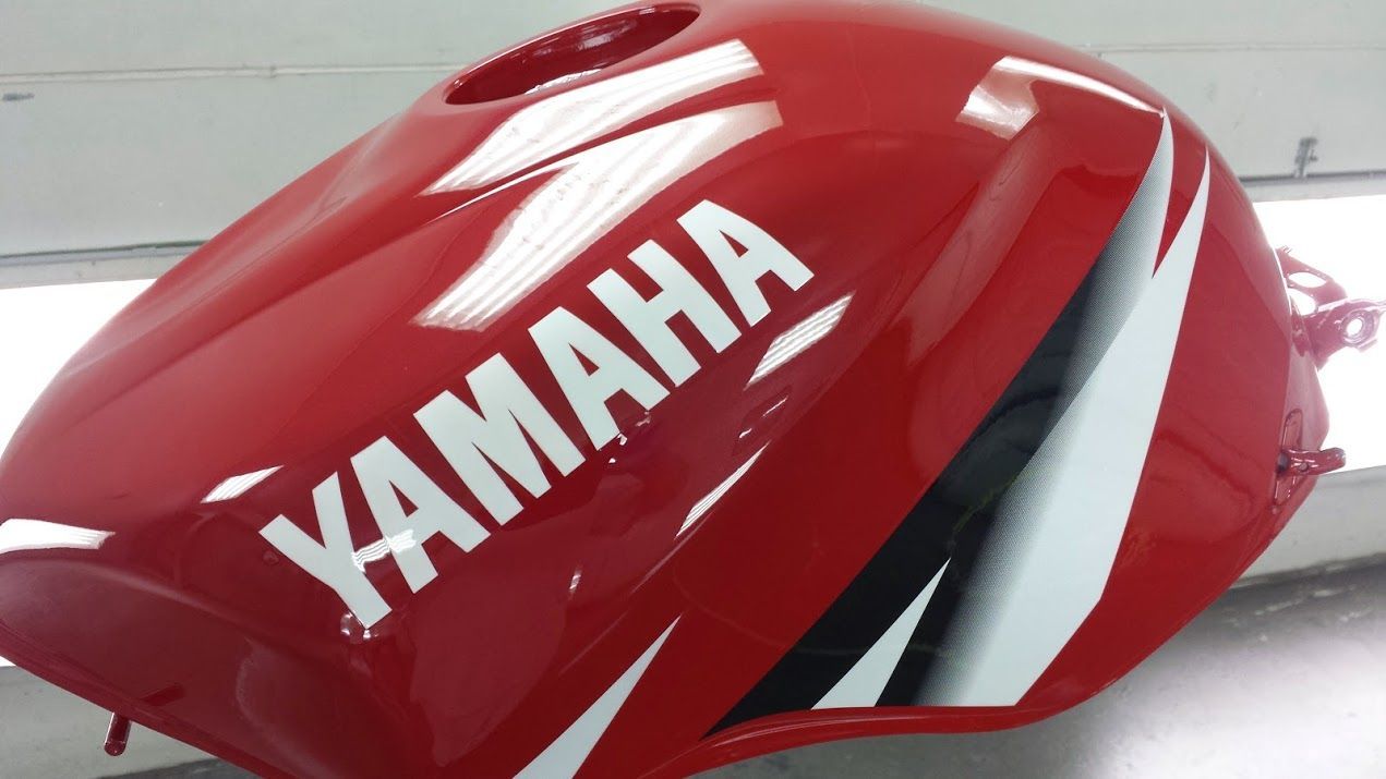 A red yamaha motorcycle tank is sitting on a table