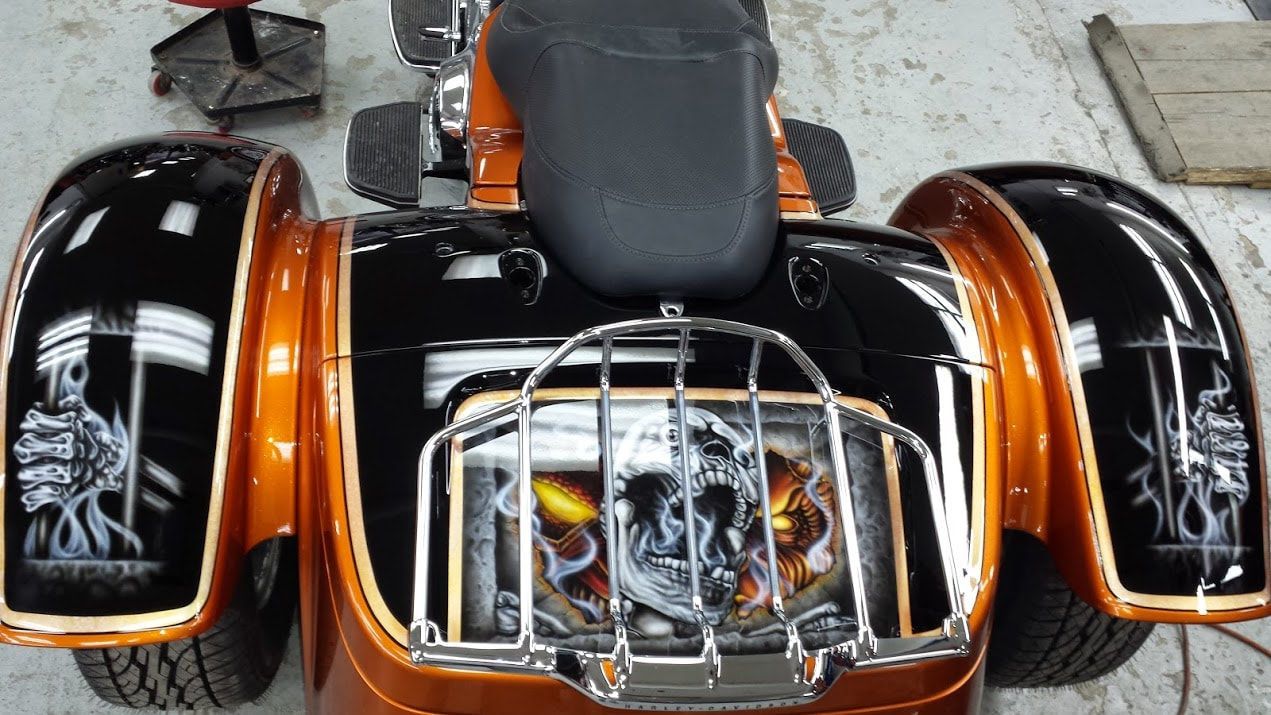 A motorcycle with three wheels is parked in a garage.