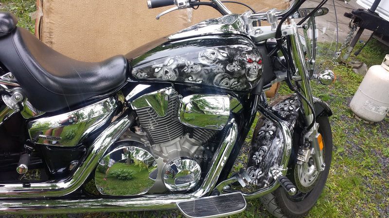 A black and silver motorcycle is parked in the grass.