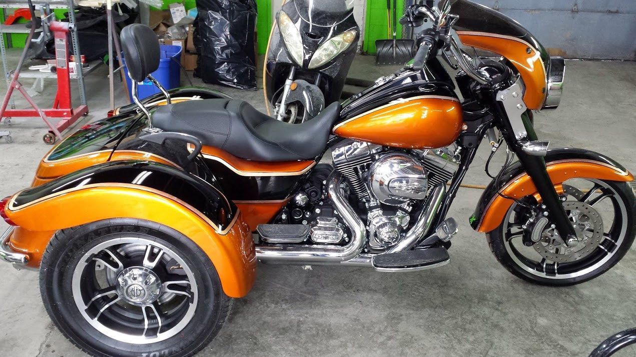 A motorcycle with three wheels is parked in a garage.