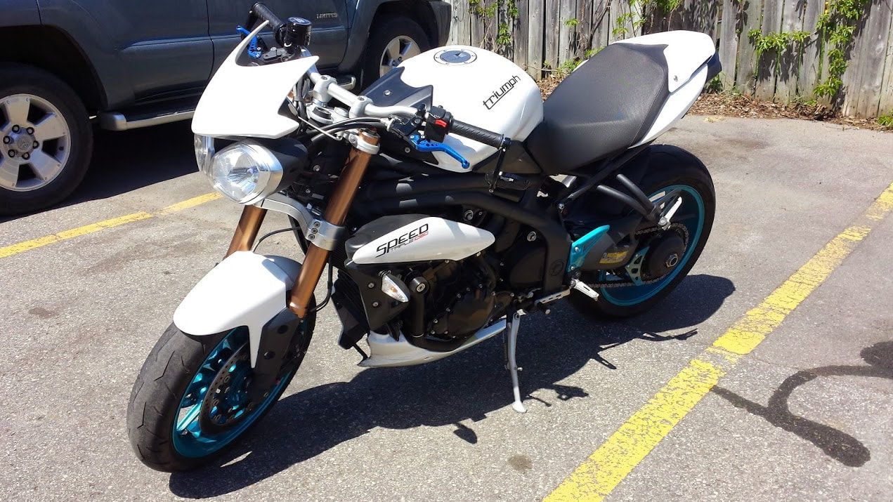 A white motorcycle is parked in a parking lot