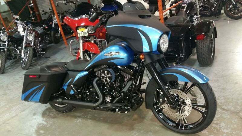 A blue and black harley davidson motorcycle is parked in a garage