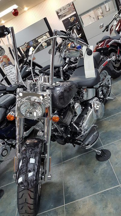 A motorcycle is parked in a showroom next to other motorcycles.