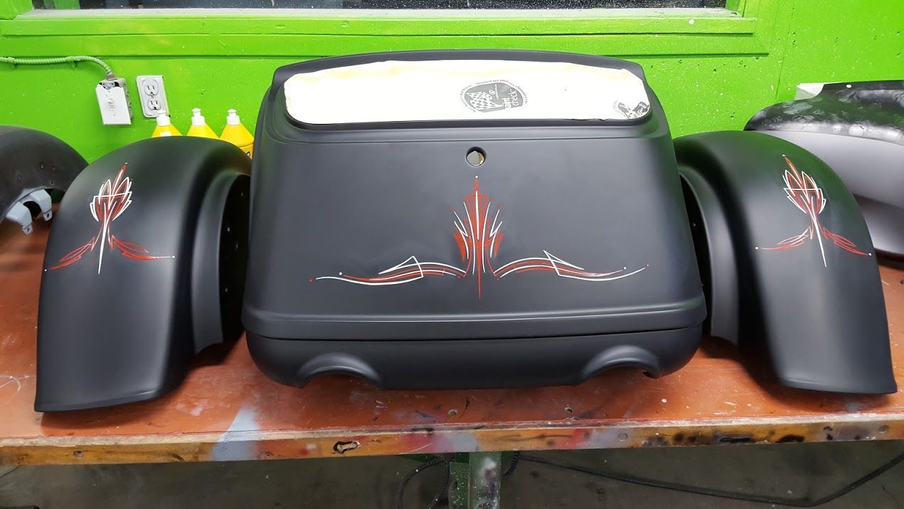 A black motorcycle is sitting on top of a wooden table.