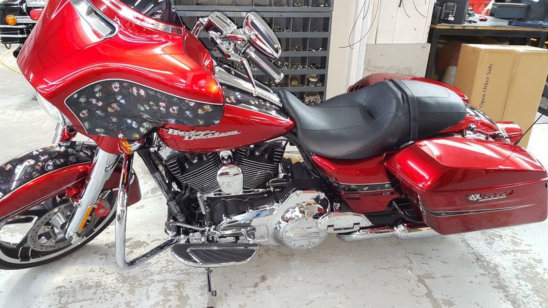 A red harley davidson motorcycle is parked in a garage.