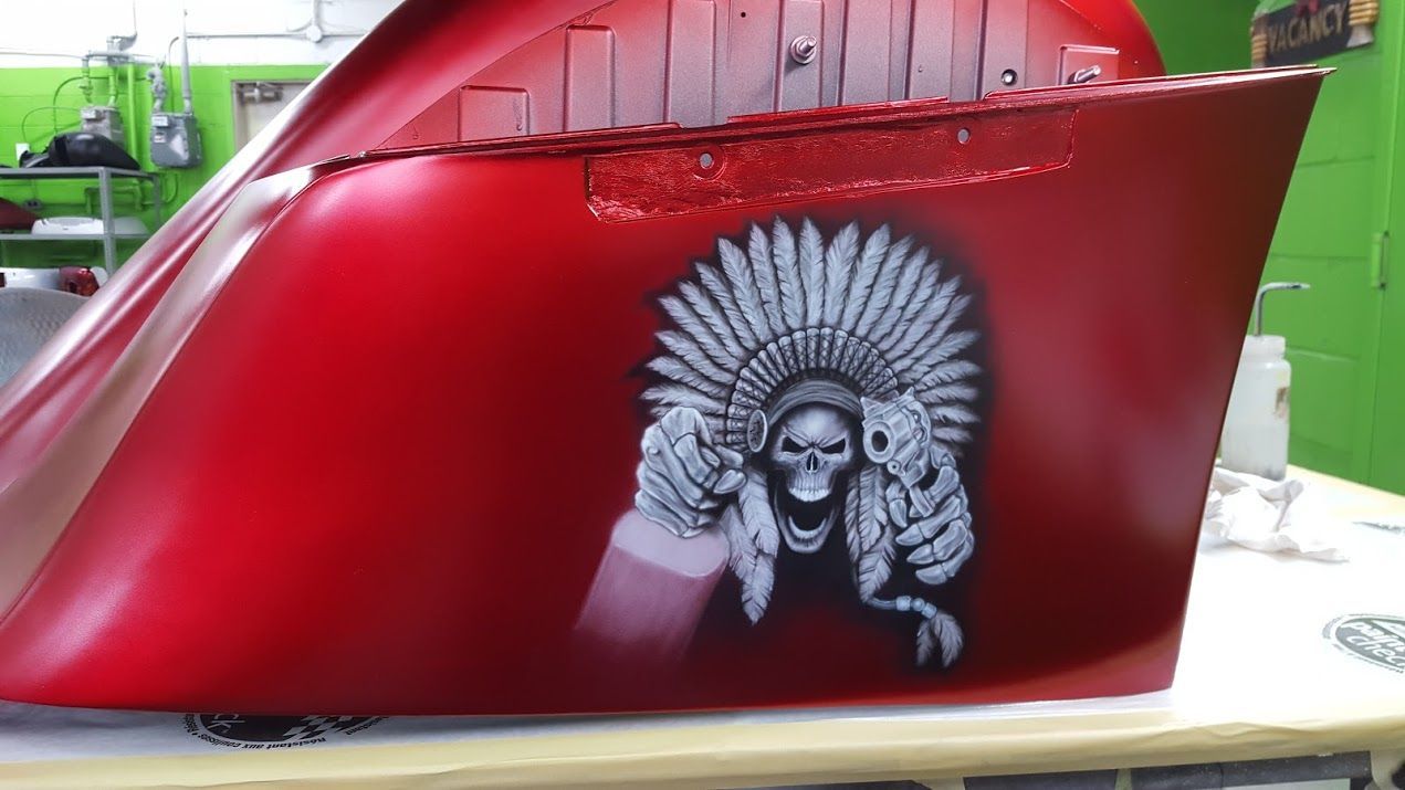 A red motorcycle with a skull and headdress painted on it