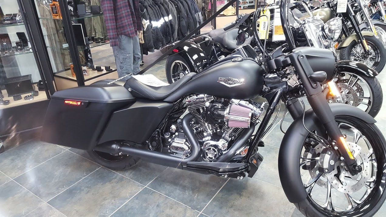 A black harley davidson motorcycle is parked in a showroom.