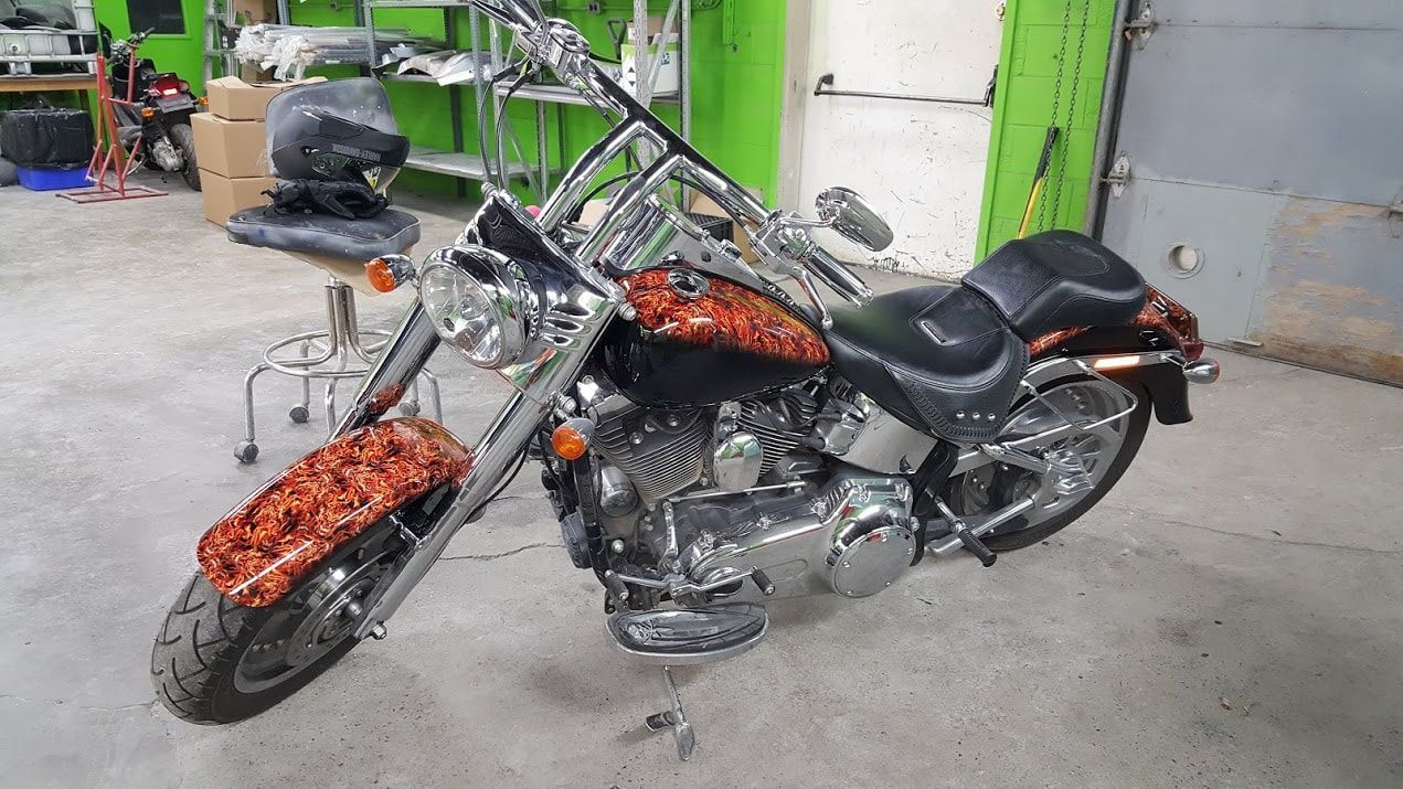 A harley davidson chopper motorcycle is parked in a garage.