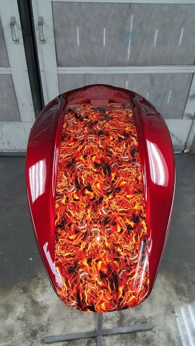 A red motorcycle tank with flames painted on it.