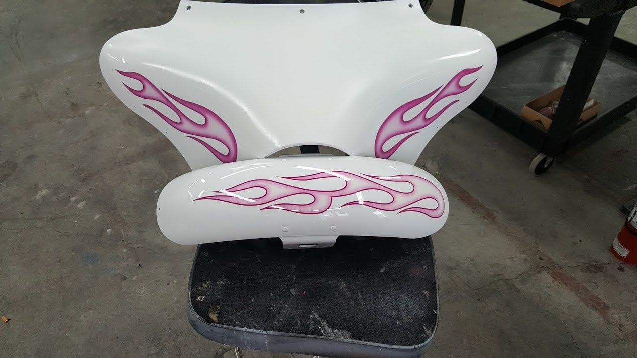 A white chair with pink flames painted on it