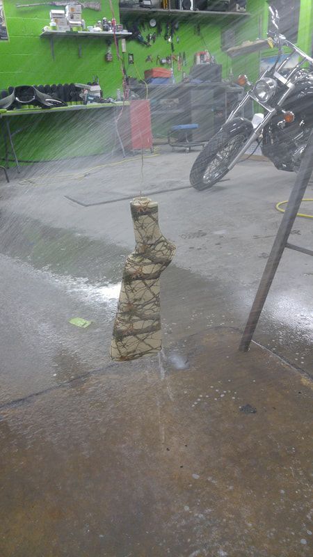 A motorcycle is parked in a garage next to a pile of rocks.