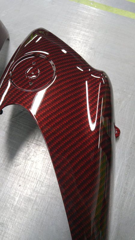 A close up of a red carbon fiber fender on a motorcycle.