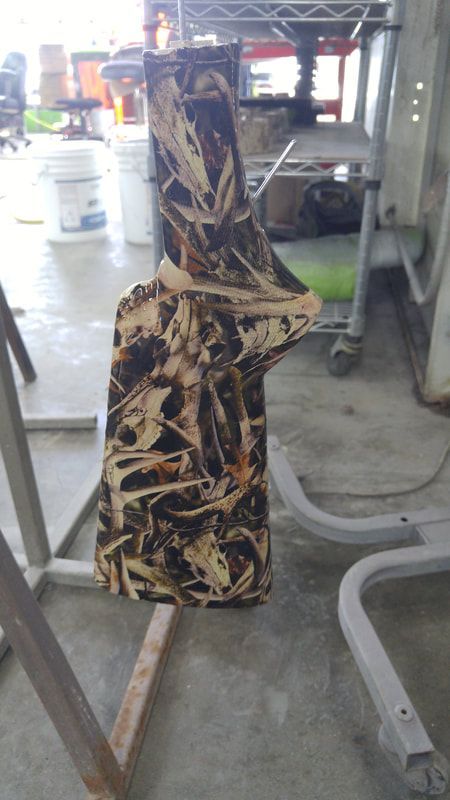 A chair with a camouflage pattern on it is sitting on a concrete floor.