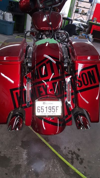 A red harley davidson motorcycle is parked in a garage.