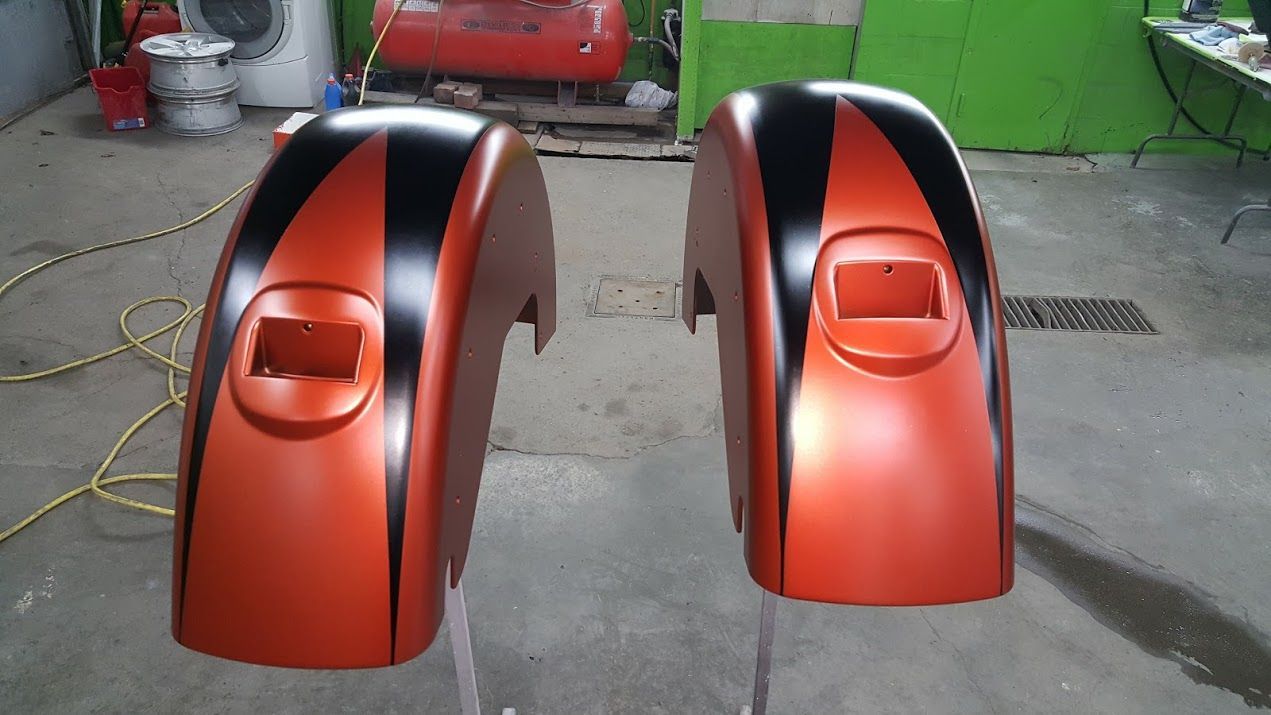 A pair of orange fenders with black stripes on them