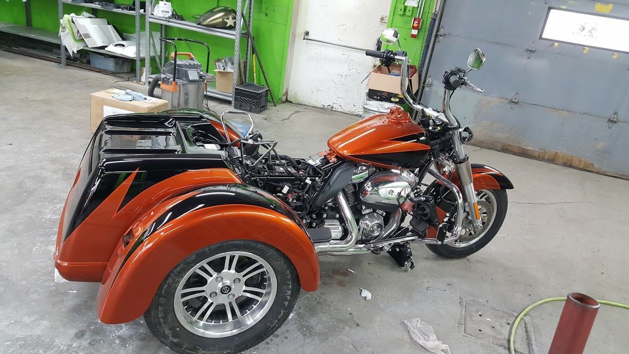 A motorcycle with a sidecar is parked in a garage.