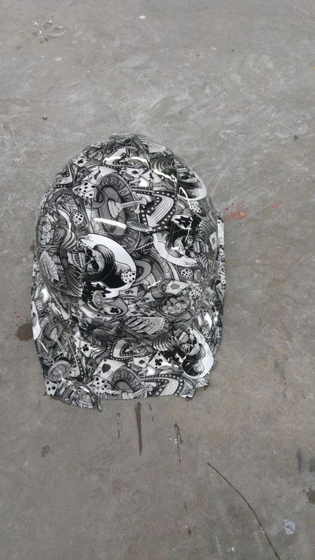 A black and white hat is sitting on a concrete surface.