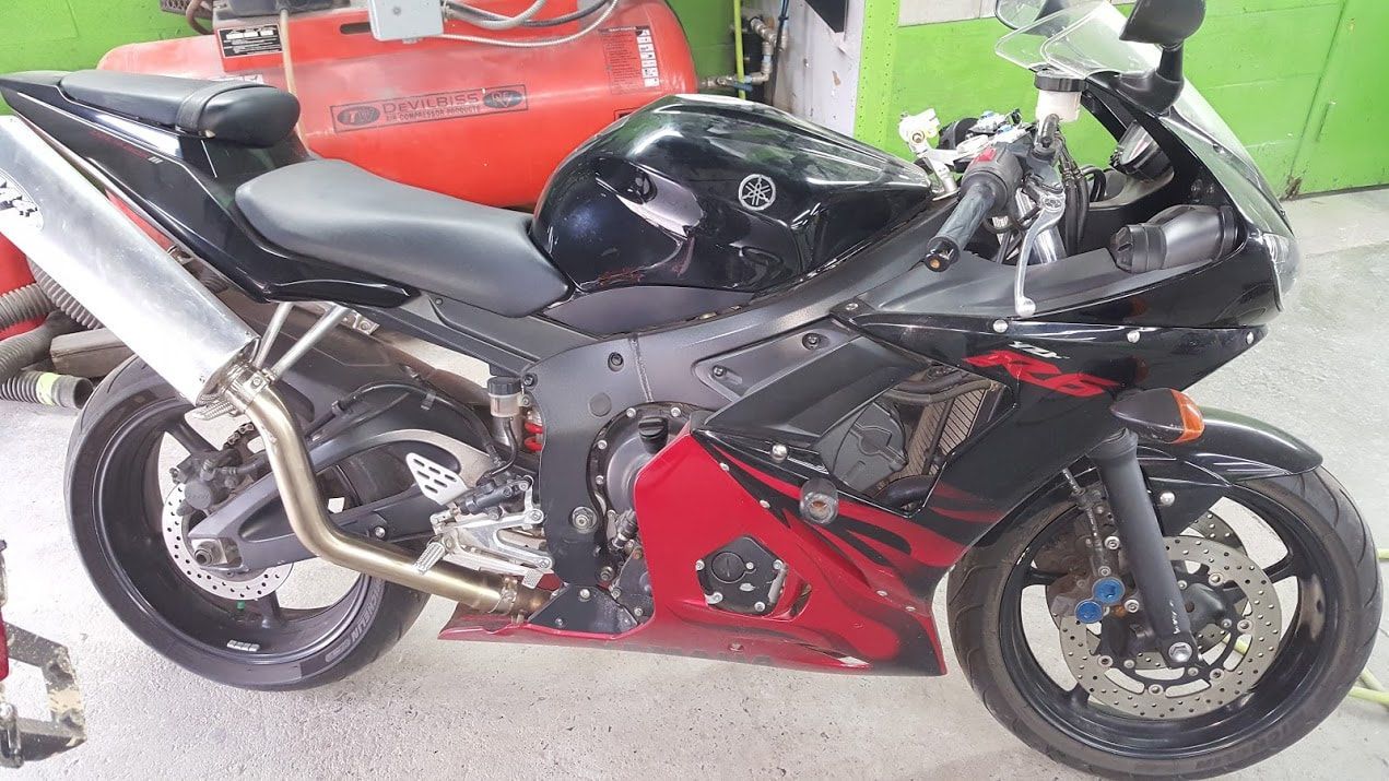A black and red motorcycle is parked in a garage
