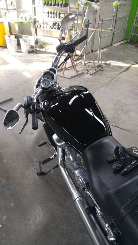 A black motorcycle is parked in a garage.