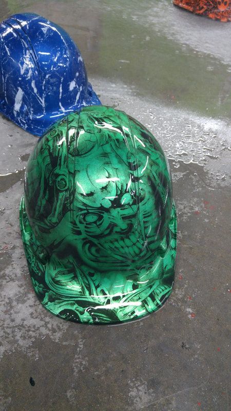 A green hard hat with a skull design on it