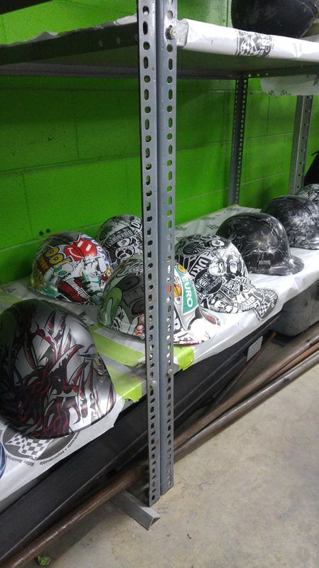 A row of hard hats are sitting on a shelf in a store.