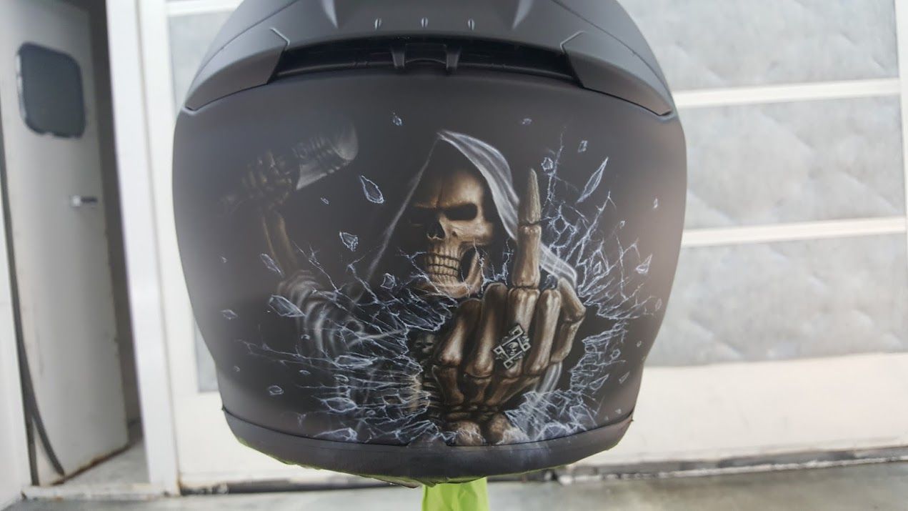 A motorcycle helmet with a grim reaper on it